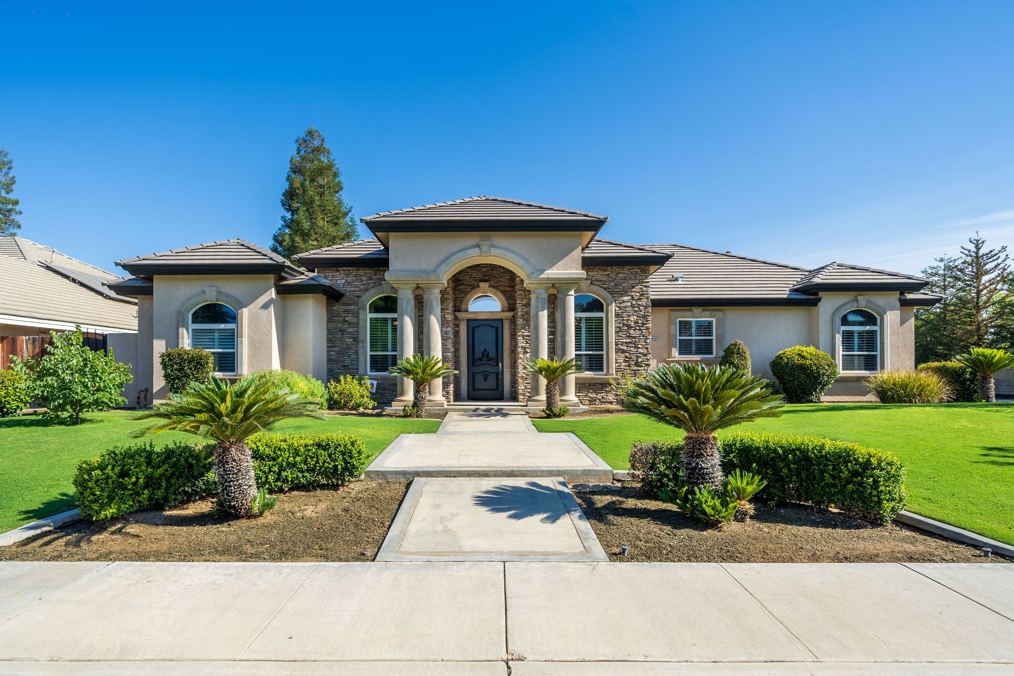 Bakersfield home with stone entry and palms